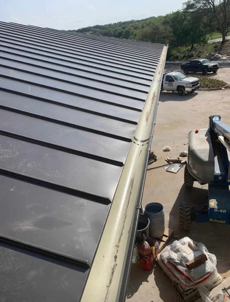 Standing seam panel and gutter detail on a metal roofing jobsite in Sheboygan Falls